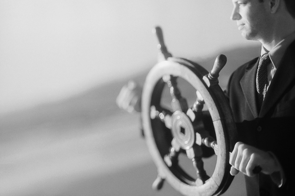 Businessman Turning Ship Wheel