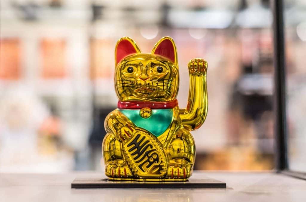Le chat Maneki-Neko doré avec sa patte articulée