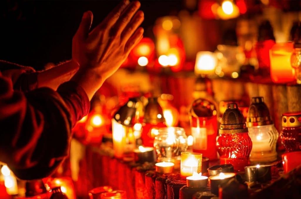 un homme prie devant des bougies le jour du nyepi