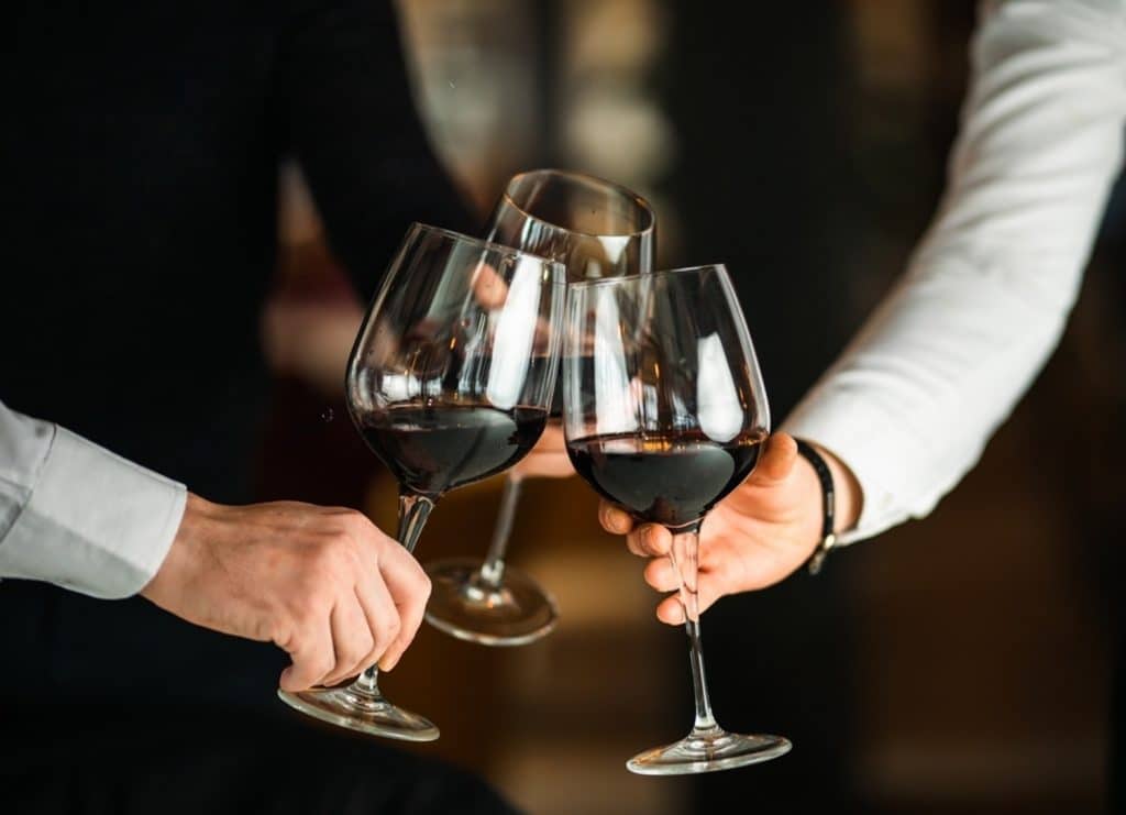 hommes qui trinquent avec un verre de vin