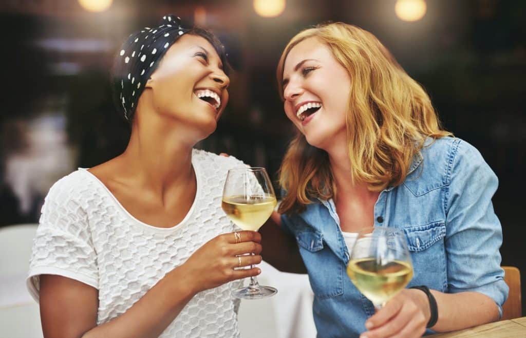 amies qui sont ensemble et rigolent avec un verre