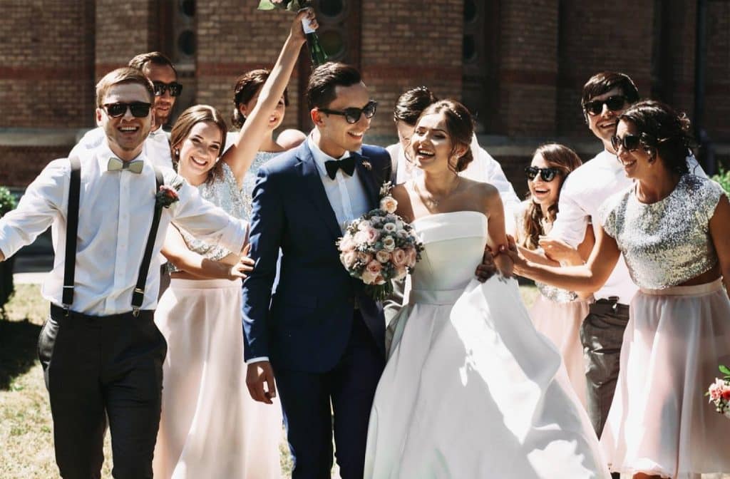 un homme et une femme à sa gauche qui sorte de la cérémonie de mariage