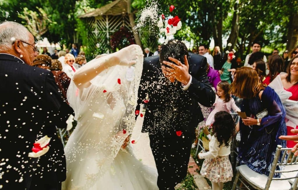 un couple de jeunes mariés qui reçoivent du riz symbole de fertilité
